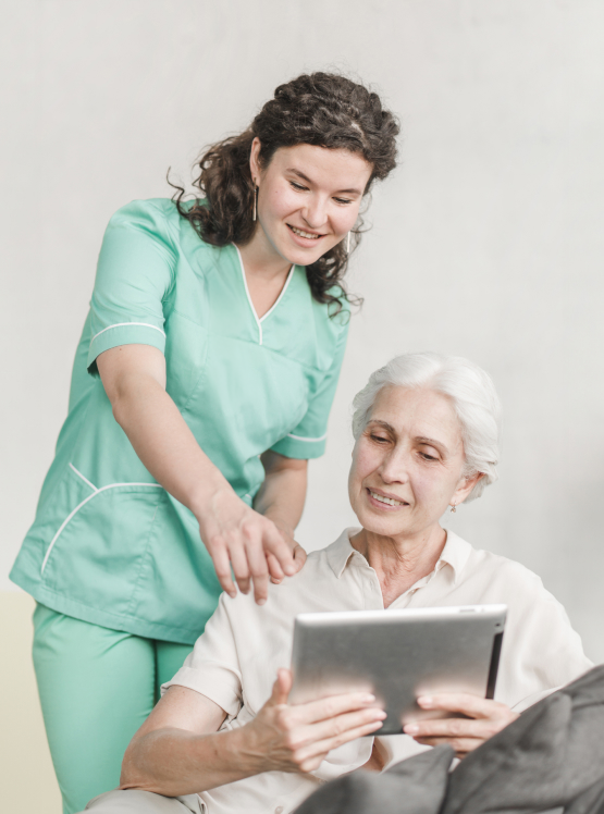 A female care worker helping an elderly woman on her tablet