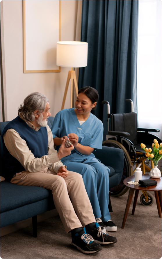 Smiling care worker assists elderly man in cozy room with his medicines, providing visiting care with compassion